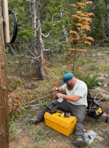 Trace fiber technician troubleshooting a damaged OSP circuit at a remote industrial site in rural Colorado